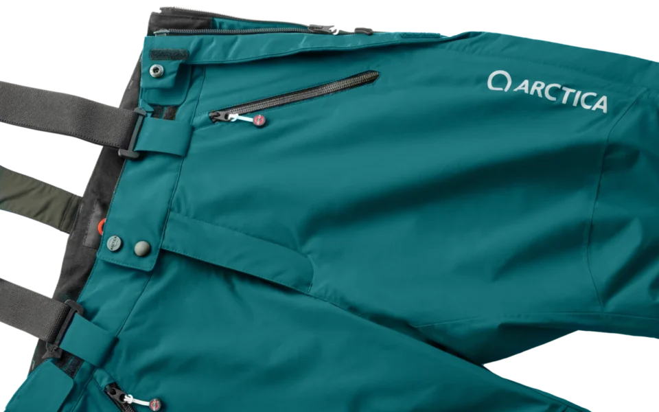 Close-up of the Arctica Side Zip Ski Pants 2.0 in Balsam showing the waistband, suspenders, zip pocket and logo.