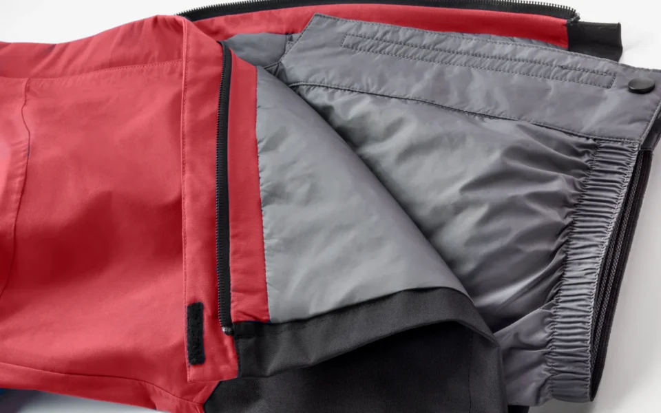 Close-up of the Arctica Side Zip Ski Pants 2.0 in Deep Red opened to show the gray lining.