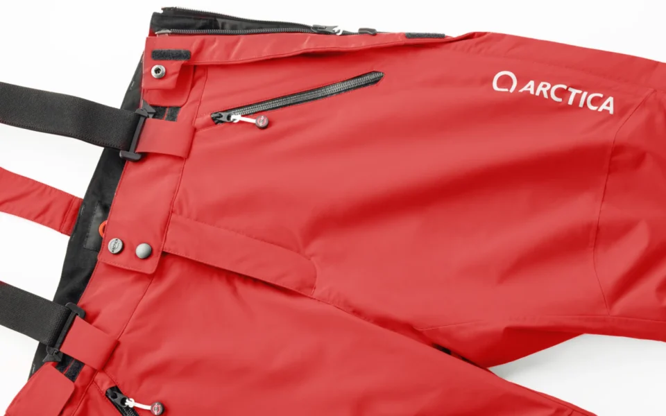 Close-up of the Arctica Side Zip Ski Pants 2.0 in Deep Red showing the waistband, suspenders, zip pocket and logo.