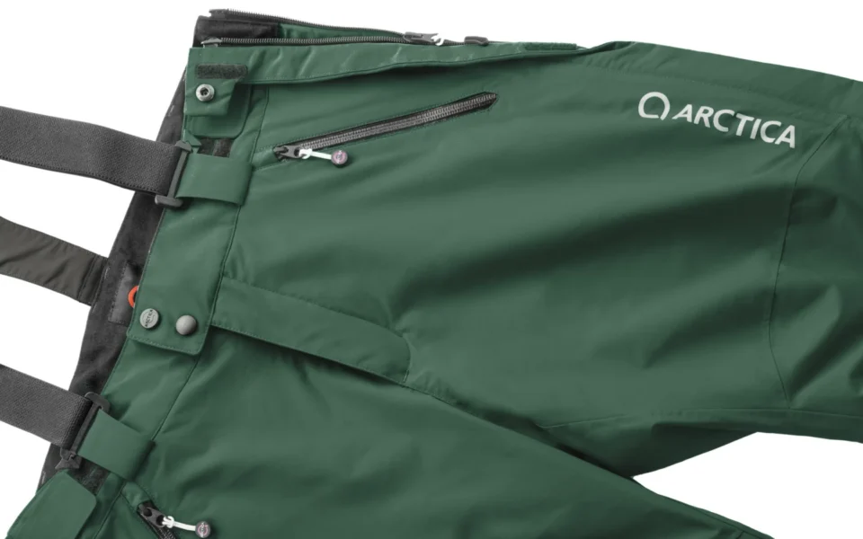 Close-up of the Arctica Side Zip Ski Pants 2.0 in Evergreen showing the waistband, suspenders, zip pocket and logo.