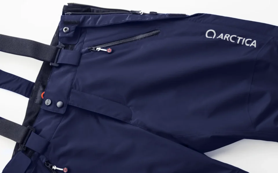 Close-up of the Arctica Side Zip Ski Pants 2.0 in Midnight showing the waistband, suspenders, zip pocket and logo.