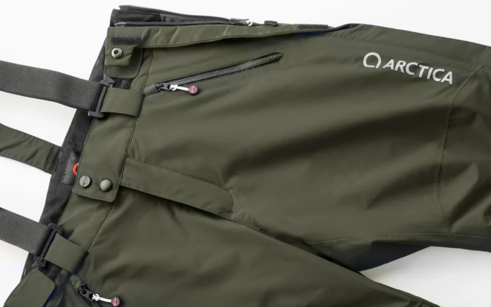 Close-up of the Arctica Side Zip Ski Pants 2.0 in OD showing the waistband, suspenders, zip pocket and logo.