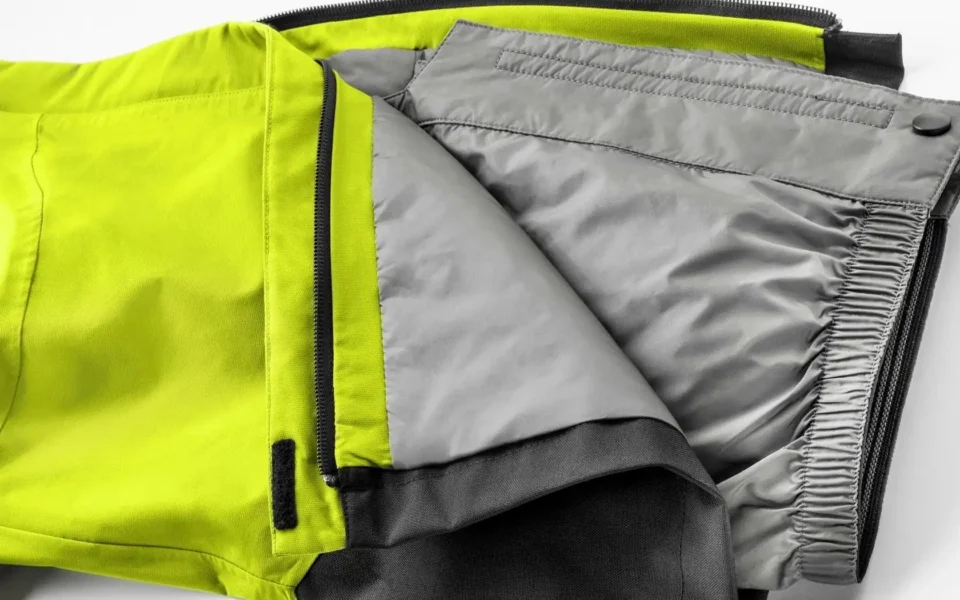 Close-up of the Arctica Side Zip Ski Pants 2.0 in Optic Yellow opened to show the gray lining.