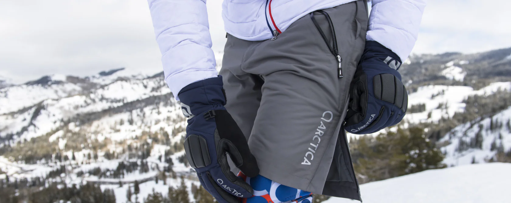 Grey Arctica side-zip training shorts pulled on over a race suit, with navy Arctica gloves